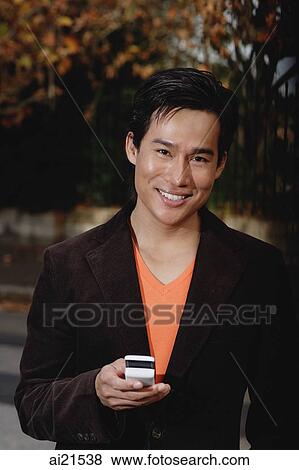 Man using mobile phone, smiling, looking at camera View Large Photo Image Stock Photo - Man using mobile phone, smiling, looking at camera. Fotosearch