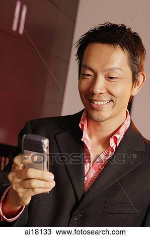 Stock Image - Man using mobile phone, test messaging. Fotosearch