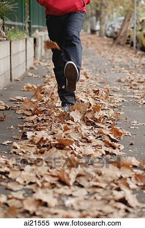 Man wearing running on leaves scattered on pavement, cropped image View Large Photo Image Stock Photography - Man wearing running on leaves scattered on pavement, cropped image. Fotosearch