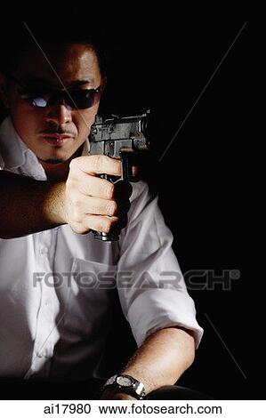 Man wearing sunglasses, pointing a gun View Large Photo Image Stock Image - Man wearing sunglasses, pointing a gun. Fotosearch