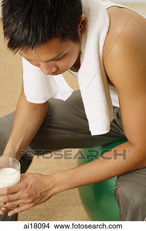 Man with towel around his neck, holding glass of milk, looking away View Large Photo Image Picture - Man with towel around his neck, holding glass of milk, looking away. Fotosearch