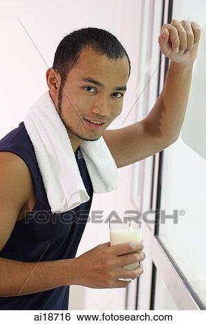 Man with towel around his neck, holding glass of water, looking at camera View Large Photo Image Stock Photograph - Man with towel around his neck, holding glass of water, looking at camera. Fotosearch