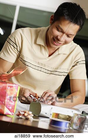 Stock Photo - Man wrapping gifts. Fotosearch