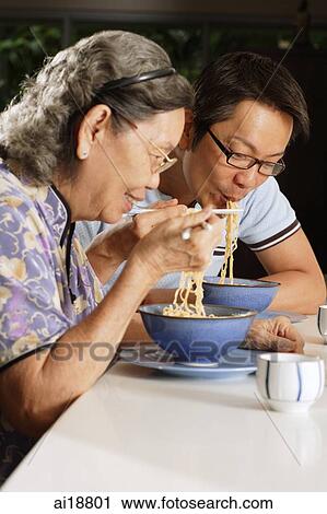 Mature son and mother eating noodles View Large Photo Image Stock Image - Mature son and mother eating noodles. Fotosearch