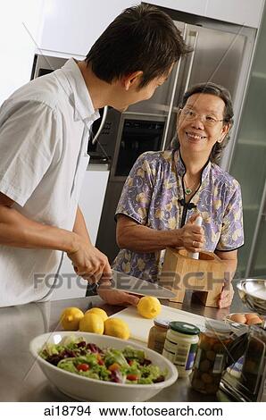 Mature son and mother in the kitchen, preparing food View Large Photo Image Picture - Mature son and mother in the kitchen, preparing food. Fotosearch