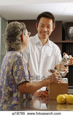 Mature son assisting mother in kitchen View Large Photo Image Stock Photography - Mature son assisting mother in kitchen. Fotosearch