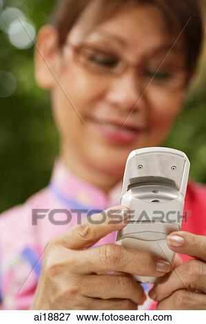 Mature woman using mobile phone, text messaging View Large Photo Image Stock Photo - Mature woman using mobile phone, text messaging. Fotosearch