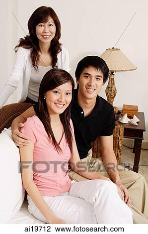 Mature woman with adult offspring in living room, looking at camera View Large Photo Image Stock Image - Mature woman with adult offspring in living room, looking at camera. Fotosearch