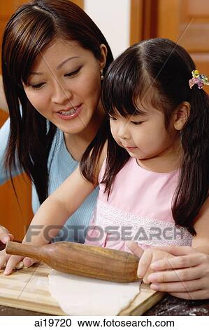 Mother and daughter rolling dough together View Large Photo Image Stock Image - Mother and daughter rolling dough together. Fotosearch
