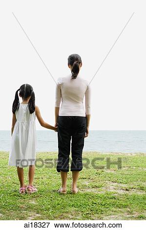 Mother and daughter, standing, looking out to sea, rear view View Large Photo Image Stock Photo - Mother and daughter, standing, looking out to sea, rear view. Fotosearch