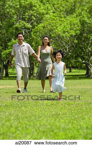 Mother and father holding hands, walking, daughter running in foreground View Large Photo Image Stock Photo - Mother and father holding hands, walking, daughter running in foreground. Fotosearch