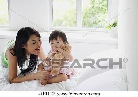 Stock Image - Mother bonding with young daughter. Fotosearch