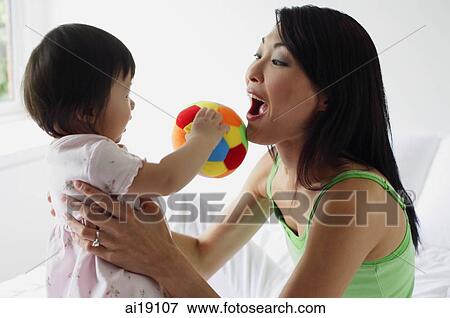 Stock Photo - Mother carrying young daughter. Fotosearch