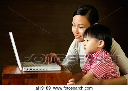 Mother with young son, looking at laptop View Large Photo Image Stock Photo - Mother with young son, looking at laptop. Fotosearch