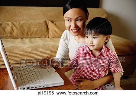 Mother with young son on lap, looking at laptop View Large Photo Image Stock Photography - Mother with young son on lap, looking at laptop. Fotosearch