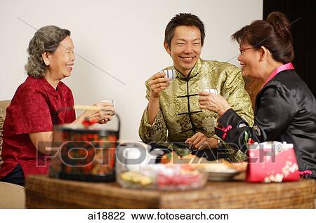 Stock Image - People in living room during Chinese New Year. Fotosearch