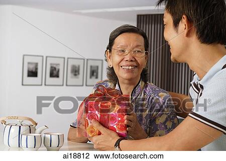 Senior woman receiving gift from mature son View Large Photo Image Stock Image - Senior woman receiving gift from mature son. Fotosearch