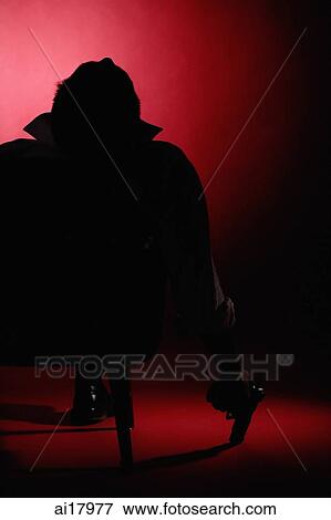Silhouette of a man sitting on chair, holding a gun View Large Photo Image Stock Photo - Silhouette of a man sitting on chair, holding a gun. Fotosearch
