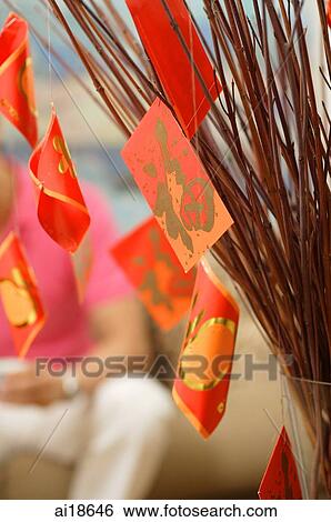 Stock Photograph - Still life of branches with red packets attached. Fotosearch