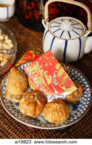 Stock Image - Still life of traditional Chinese pastries and red packet. Fotosearch