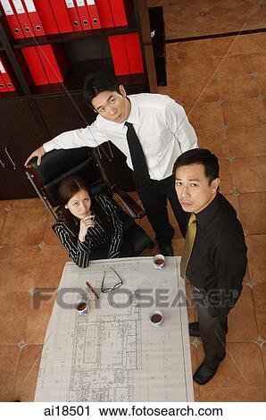 Two businessmen and businesswoman looking at camera, high angle view View Large Photo Image Stock Image - Two businessmen and businesswoman looking at camera, high angle view. Fotosearch