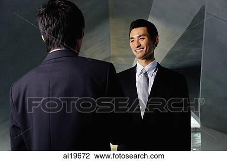 Two businessmen shaking hands, over the shoulder view View Large Photo Image Stock Image - Two businessmen shaking hands, over the shoulder view. Fotosearch