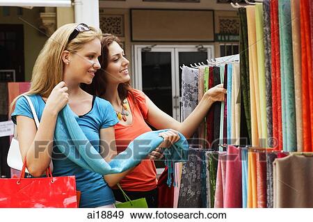 Two Caucasian women shopping, looking at cloth View Large Photo Image Stock Photo - Two Caucasian women shopping, looking at cloth. Fotosearch