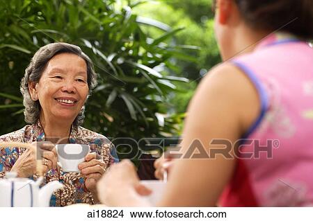 Two women having tea outdoors View Large Photo Image Picture - Two women having tea outdoors. Fotosearch