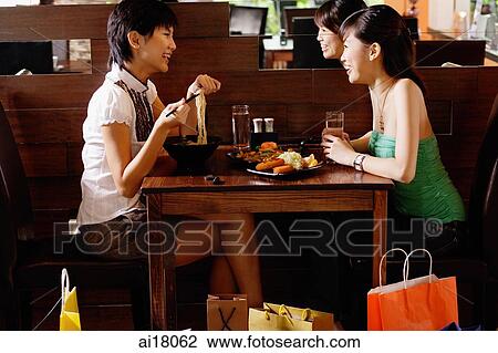 Two young women having a meal in restaurant View Large Photo Image Stock Image - Two young women having a meal in restaurant. Fotosearch