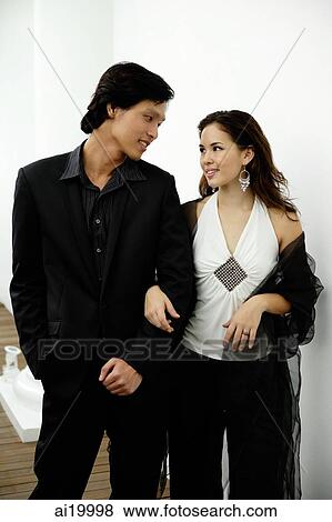 Well dressed couple standing arm in arm View Large Photo Image Stock Photo - Well dressed couple standing arm in arm. Fotosearch