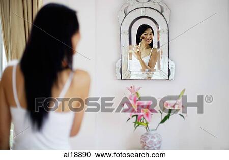 Woman applying make-up with brush, looking into mirror View Large Photo Image Stock Image - Woman applying make-up with brush, looking into mirror. Fotosearch