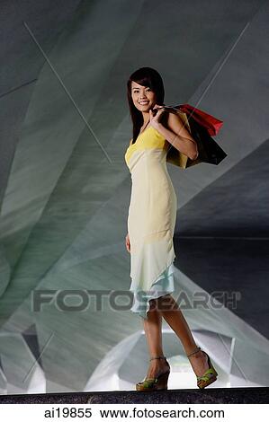 Stock Photography - Woman carrying shopping bag. Fotosearch
