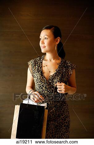 Woman carrying shopping bags, looking away View Large Photo Image Stock Image - Woman carrying shopping bags, looking away. Fotosearch