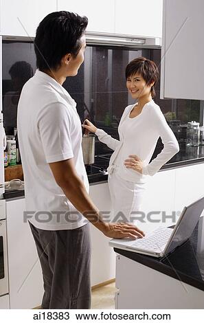Woman cooking on stove, man with laptop, looking at each other View Large Photo Image Stock Image - Woman cooking on stove, man with laptop, looking at each other. Fotosearch