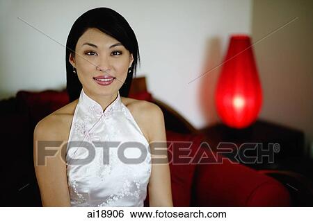 Woman dressed in Chinese cheongsam, smiling at camera View Large Photo Image Stock Photograph - Woman dressed in Chinese cheongsam, smiling at camera. Fotosearch