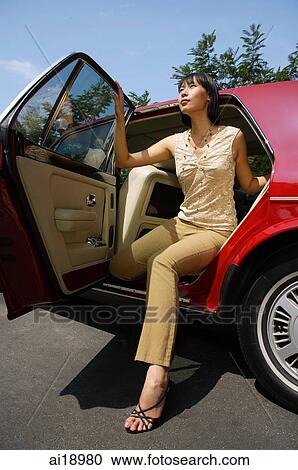 Woman getting out of red car View Large Photo Image Stock Image - Woman getting out of red car. Fotosearch