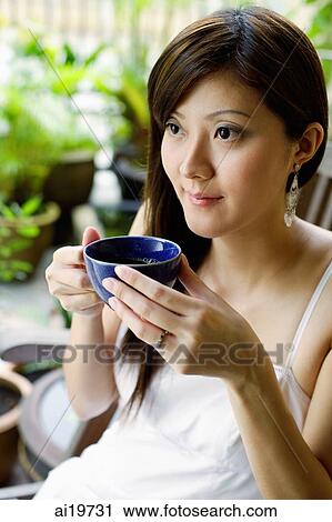 Woman holding cup, looking away View Large Photo Image Stock Image - Woman holding cup, looking away. Fotosearch