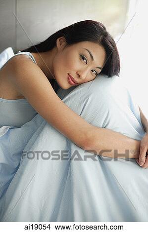 Woman hugging knees, smiling at camera View Large Photo Image Picture - Woman hugging knees, smiling at camera. Fotosearch
