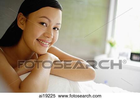 Woman hugging knees, smiling, looking away View Large Photo Image Stock Photography - Woman hugging knees, smiling, looking away. Fotosearch