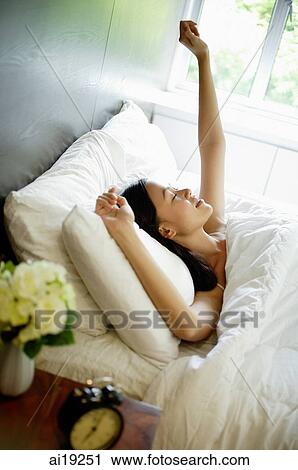 Woman in bed, stretching View Large Photo Image Stock Image - Woman in bed, stretching. Fotosearch