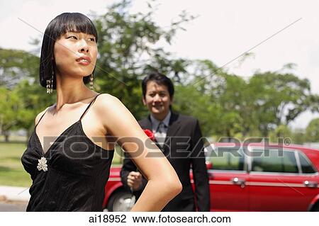 Woman in black dress, looking away, man in the background View Large Photo Image Stock Image - Woman in black dress, looking away, man in the background. Fotosearch