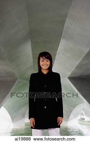 Woman in black jacket standing in tunnel, smiling View Large Photo Image Stock Photo - Woman in black jacket standing in tunnel, smiling. Fotosearch