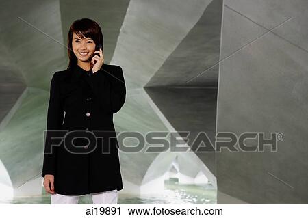 Woman in black jacket, using mobile phone, smiling View Large Photo Image Stock Image - Woman in black jacket, using mobile phone, smiling. Fotosearch