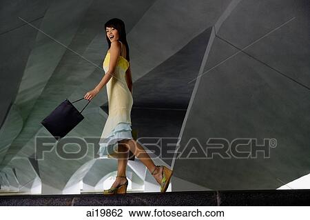 Woman in dress and platform shoes, carrying shopping bag View Large Photo Image Stock Image - Woman in dress and platform shoes, carrying shopping bag. Fotosearch