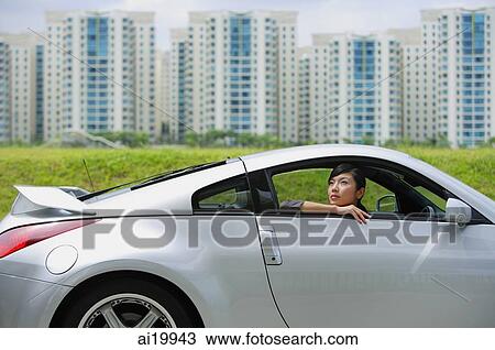 Woman in front seat of silver sports car, looking out the window View Large Photo Image Stock Image - Woman in front seat of silver sports car, looking out the window. Fotosearch