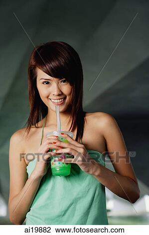 Woman in green top drinking green drink View Large Photo Image Stock Image - Woman in green top drinking green drink. Fotosearch