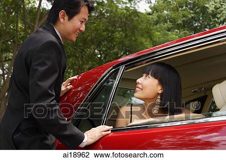 Woman in red car, man standing next to door of car, looking at each other, smiling View Large Photo Image Stock Image - Woman in red car, man standing next to door of car, looking at each other, smiling. Fotosearch