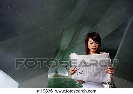 Stock Photograph - Woman in tunnel, reading newspaper. Fotosearch