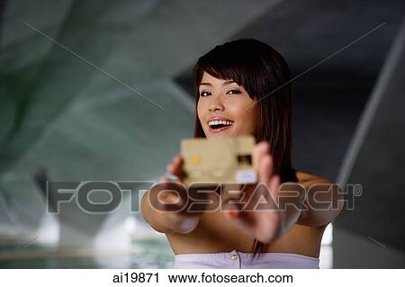 Woman in white tube top holding credit card towards camera View Large Photo Image Stock Image - Woman in white tube top holding credit card towards camera. Fotosearch