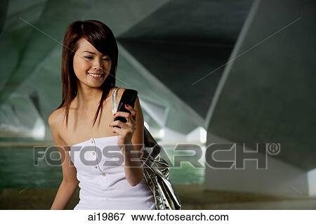 Woman in white tube top using mobile phone, text messaging View Large Photo Image Stock Photo - Woman in white tube top using mobile phone, text messaging. Fotosearch